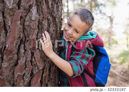Portrait of happy boy embracing tree Portrait of happy boy embracing tree 32333197