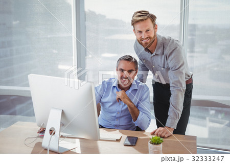 Portrait of smiling executives at desk 32333247