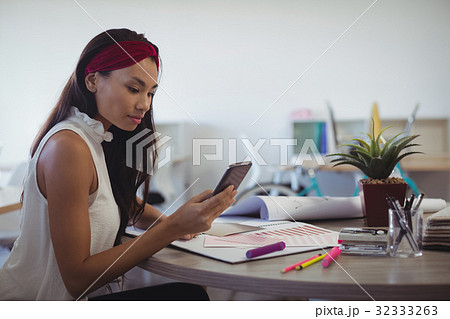 Businesswoman using mobile phone at creative office 32333263