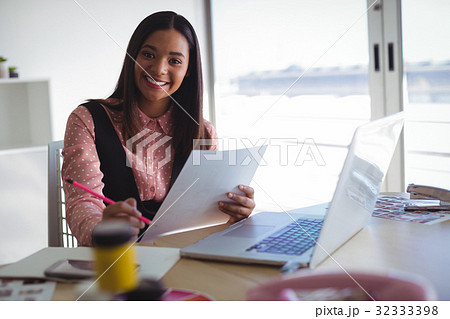 Portrait businesswoman holding document at creative office 32333398