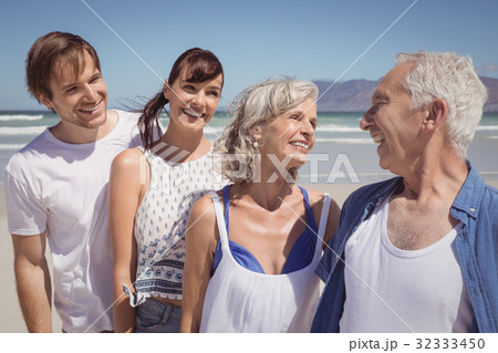 Happy family standing in row at beach Happy family standing in row at beach 32333450