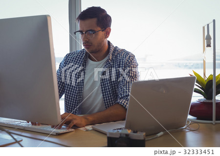 Male graphic designer using computer in creative office Male graphic designer using computer in creative office 32333451