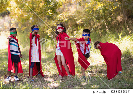 Friends enjoying while wearing superhero costume at campsite Friends enjoying while wearing superhero costume at campsite 32333617