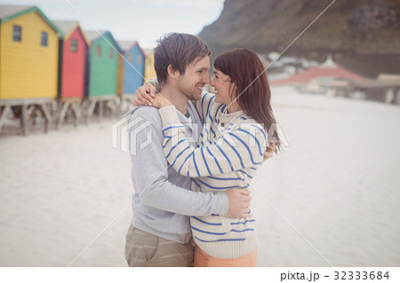 Smiling couple embracing at beach 32333684