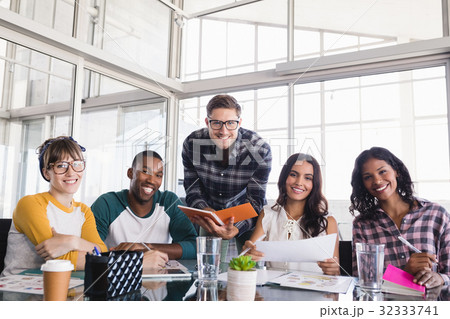 Portrait of smiling business colleagues discussing at creative office Portrait of smiling business colleagues discussing at creative office 32333741