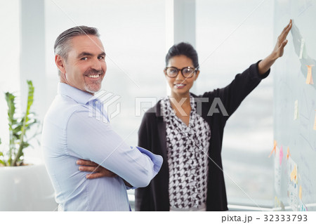 Portrait of smiling colleagues discussing over sticky note Portrait of smiling colleagues discussing over sticky note 32333793