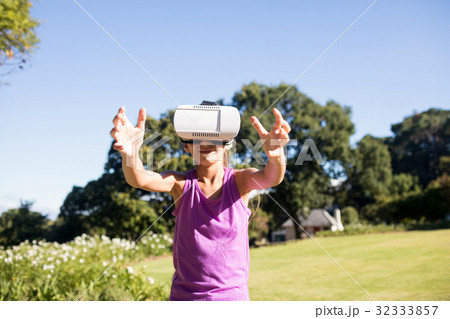 Girl using vr headset in the park Girl using vr headset in the park 32333857