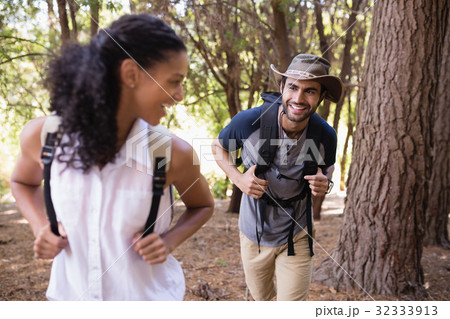 Happy couple looking at each other in forest Happy couple looking at each other in forest 32333913