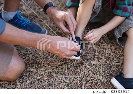 High angle view of father tying shoelace for son High angle view of father tying shoelace for son 32333914