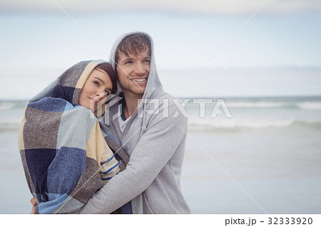Thoughtful youn couple embracing during winter Thoughtful youn couple embracing during winter 32333920