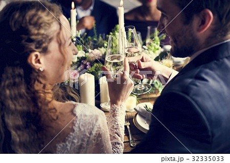 Bride and Groom Clinging Wineglasses Together at Wedding Recepti 32335033
