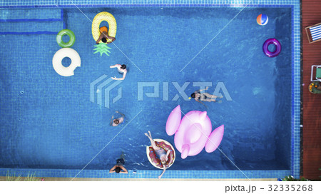 Aerial view of people enjoying the pool with inflatable tubes Aerial view of people enjoying the pool with inflatable tubes 32335268