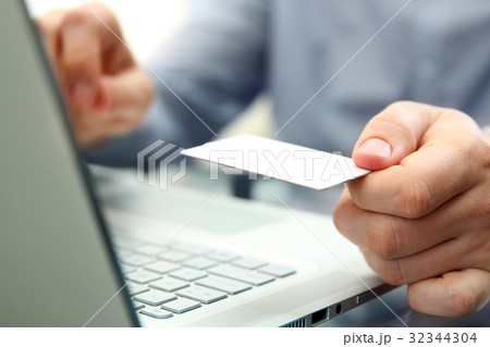 Man entering data of a credit card. Shopping  32344304