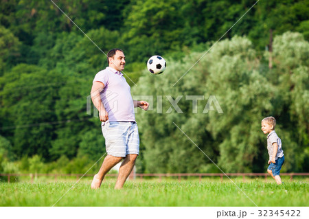 Father and son playing football 32345422
