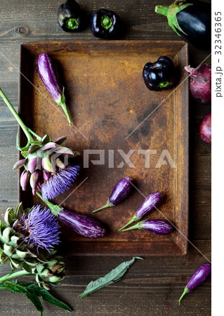 錆びたトレーとアーティチョークの花と茄子の写真素材