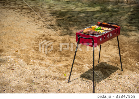 水辺のバーベキュー　肉の炭焼き　太いソーセージの丸焼き 32347958