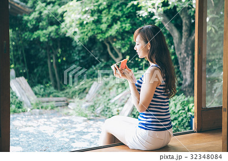 縁側でスイカを食べる女性 32348084