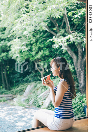 縁側でスイカを食べる女性 32348085