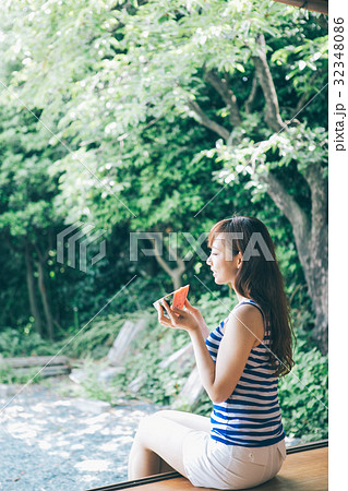 縁側でスイカを食べる女性 32348086