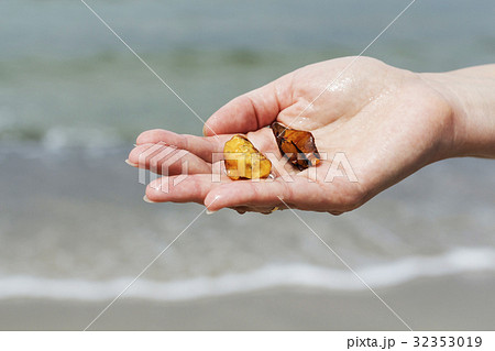 Amber in the hand with a bright reflection on the Amber in the hand with a bright reflection on the 32353019