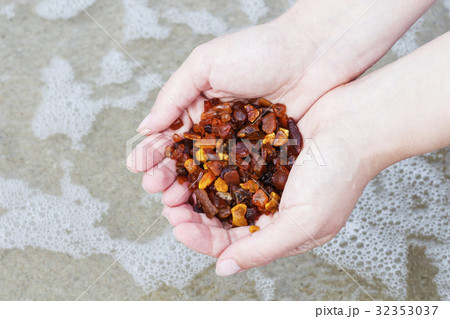Amber in the hand with a bright reflection on the Amber in the hand with a bright reflection on the 32353037