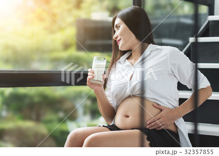 Asian pregnant woman drinking milk. 32357855