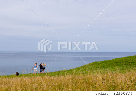 Boy sitting on te edge of a scarp, above the sea Boy sitting on te edge of a scarp, above the sea 32360879