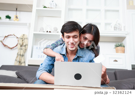 Happy couple online shopping at home Happy couple online shopping at home 32362124