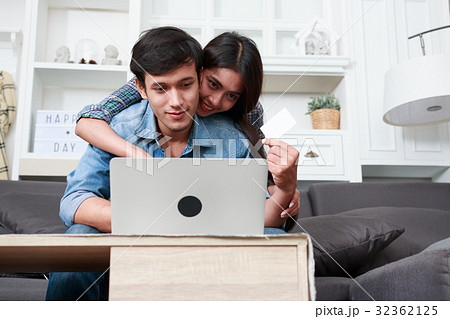 Happy couple online shopping at home Happy couple online shopping at home 32362125