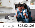 Happy couple online shopping at home 32362126