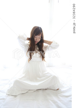 Asian young woman wake up with pillow in white room Asian young woman wake up with pillow in white room 32364290