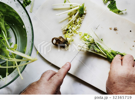 Closeup of hands with knife cutting fresh organic vegetable Closeup of hands with knife cutting fresh organic vegetable 32365719