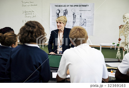Biology teacher teaching anatomy with diverse high school students Biology teacher teaching anatomy with diverse high school students 32369163