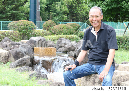 水の流れる公園で涼むシニア 32373316