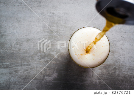 Beer pouring out of a can into a glass 32376721