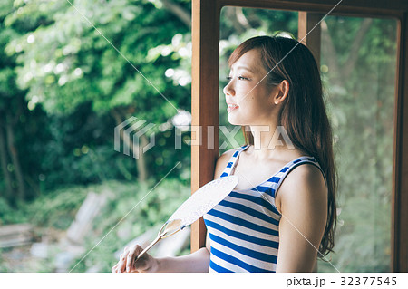 縁側でうちわをあおぐ女性 32377545