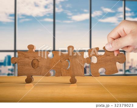 hand holding brown jigsaw 32379023