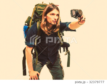 Man tourist backpacker taking photo with camera. 32379777