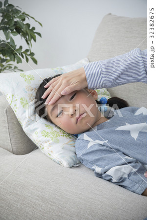 体調不良の子供の熱を測る母親 体調不良の子供の熱を測る母親 32382675