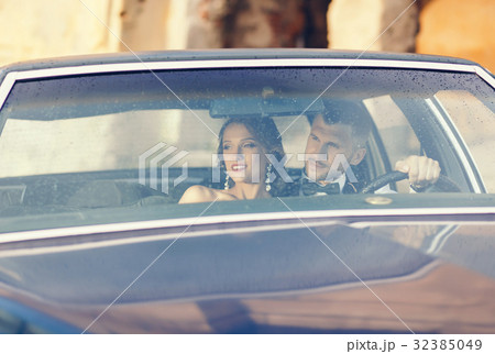 bride and handsome groom embracing in stylish car 32385049