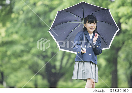 傘をさす小学生の女の子の写真素材
