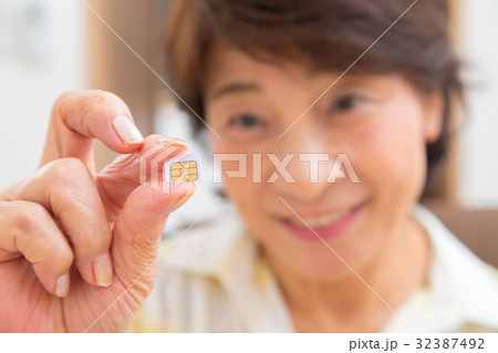 シムカードを持つシニア世代の女性の手元 シニア ポートレート 50代 60代 シムカードを持つシニア世代の女性の手元 シニア ポートレート 50代 60代 32387492