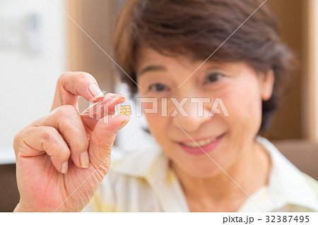 シムカードを持つシニア世代の女性の手元　シニア　ポートレート　50代　60代 32387495