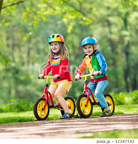 Kids ride balance bike in park Kids ride balance bike in park 32387592