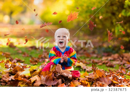 Child in fall park. Kid with autumn leaves. 32387675