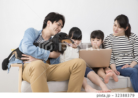 パソコンを見る家族と愛犬 パソコンを見る家族と愛犬 32388379