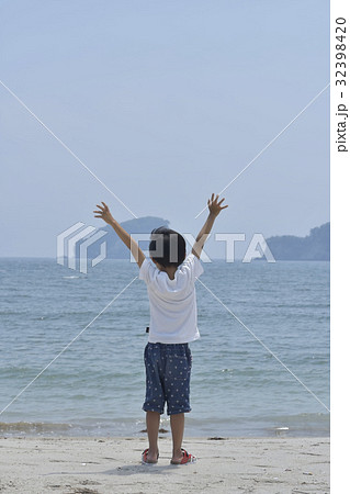 海で両手を挙げる男の子 32398420