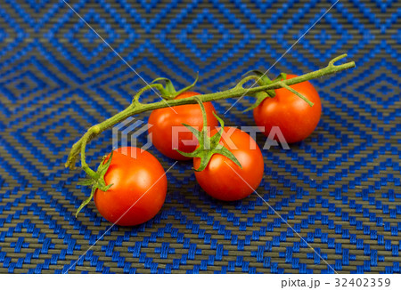 Juicy tomatoes on a green branch against Juicy tomatoes on a green branch against 32402359