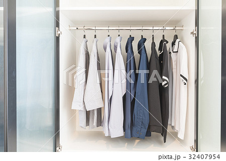 clothes hanging on rail in wooden white wardrobe clothes hanging on rail in wooden white wardrobe 32407954