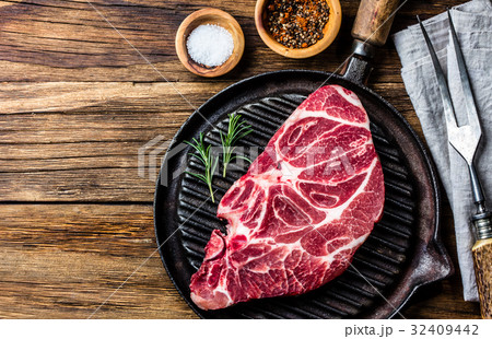 Raw marbled beef steak on grill pan Raw marbled beef steak on grill pan 32409442